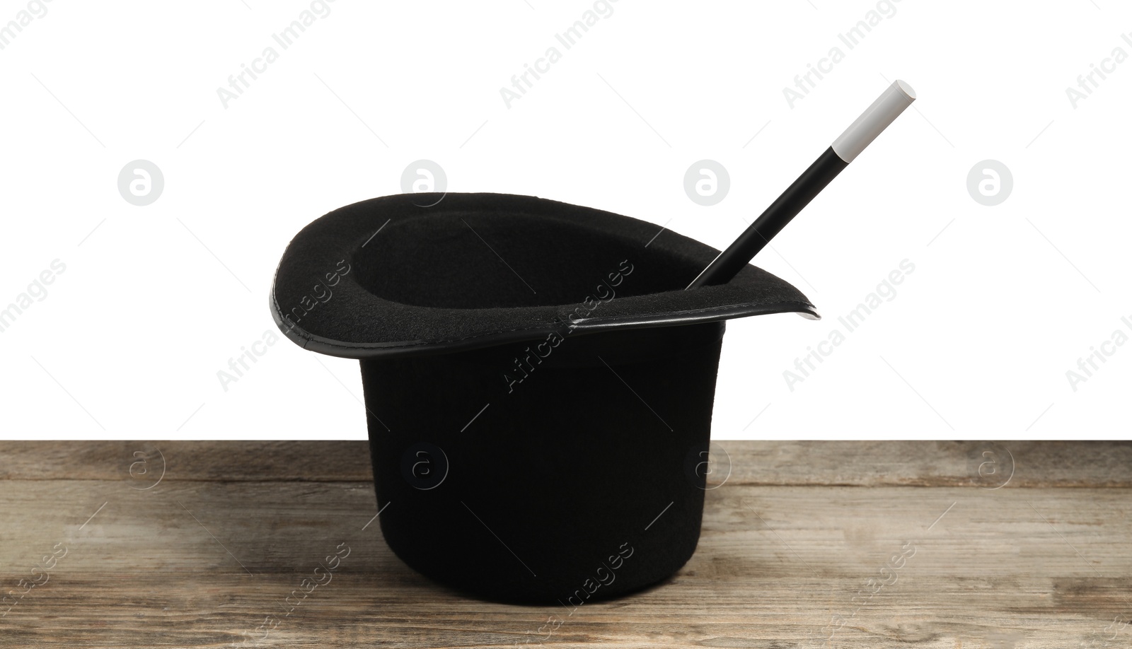 Photo of Magician's hat and wand on wooden table against white background