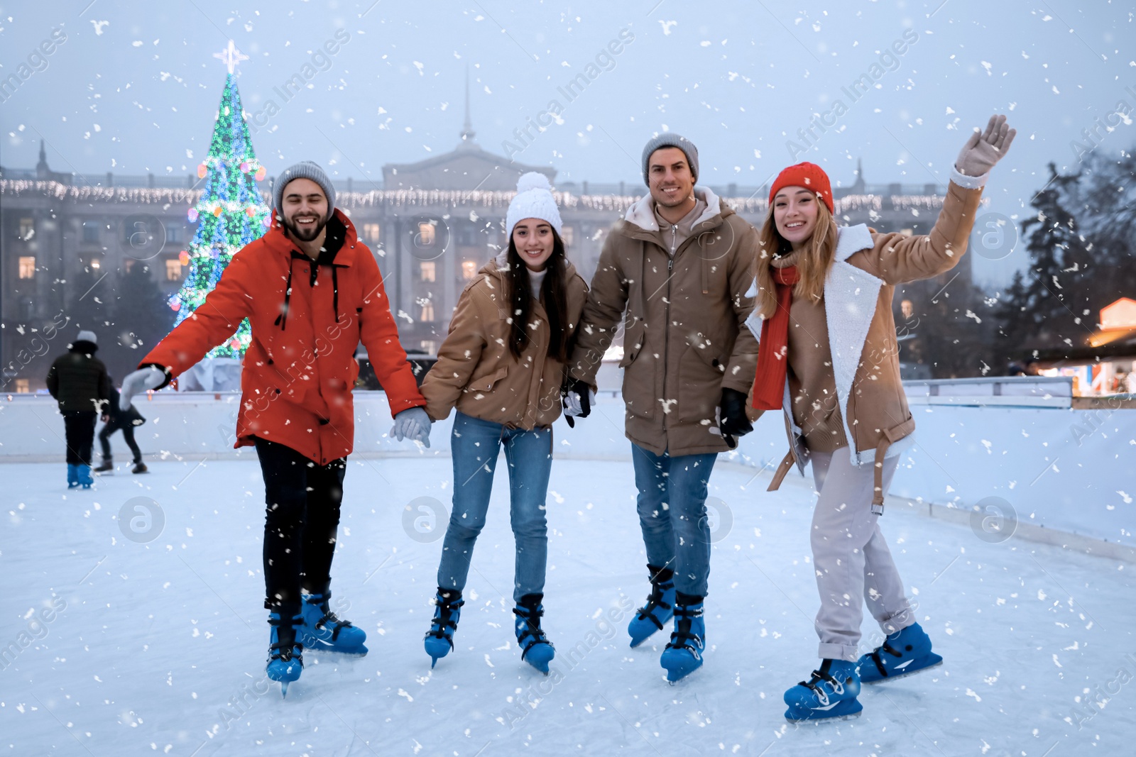 Image of Group of friends skating at outdoor ice rink