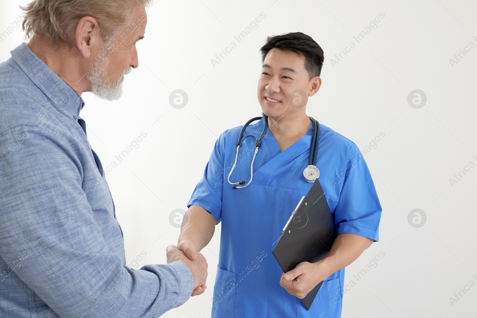 Photo of Happy doctor shaking hands with patient on white background
