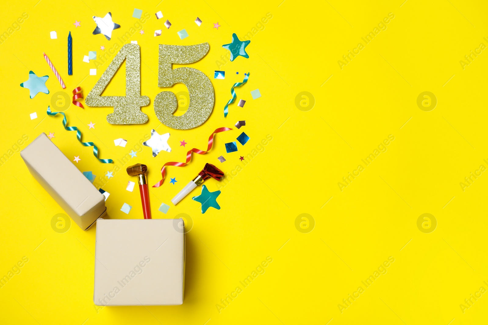 Photo of Flat lay composition with decor and numbers on yellow background, space for text. 45th birthday party