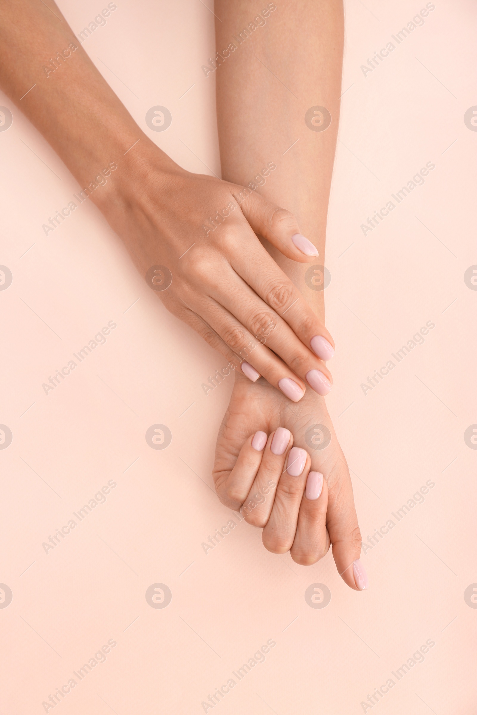 Photo of Closeup view of woman with beautiful hands on color background. Spa treatment