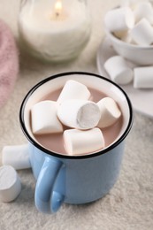 Cup of aromatic hot chocolate with marshmallows served on table, closeup