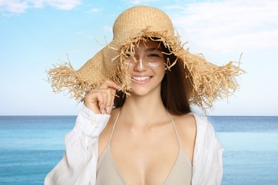 Image of Teenage girl with sun protection cream on her face near sea 