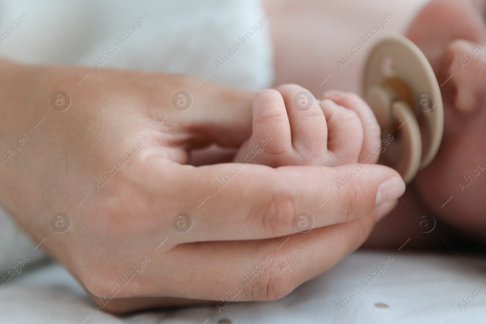 Photo of Mother and her cute newborn baby on bed, closeup