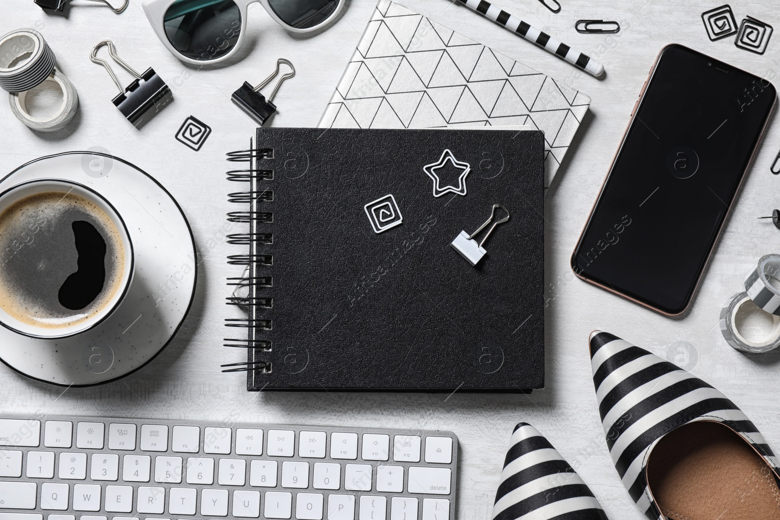 Photo of Flat lay composition with notebook and cup of coffee on light table