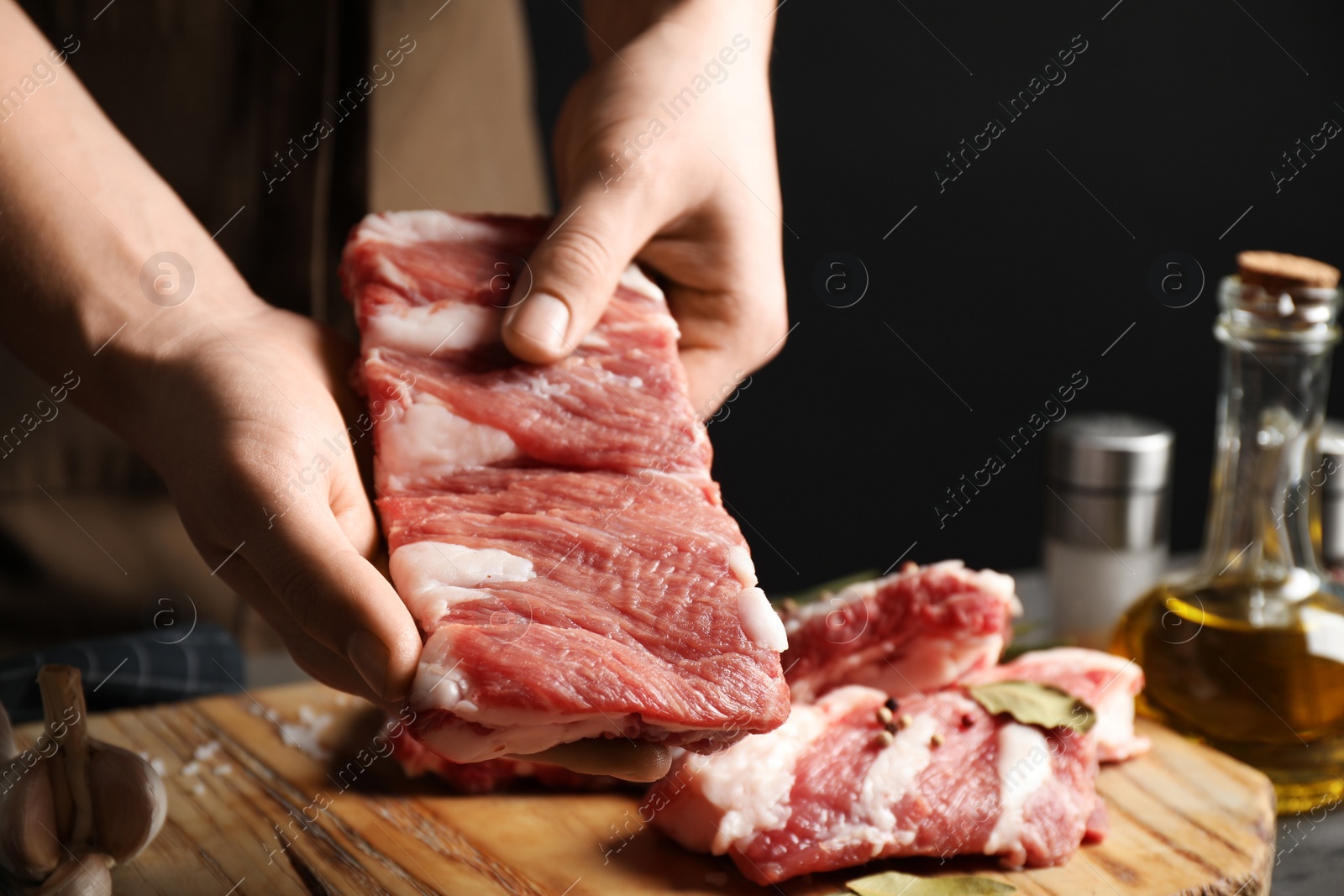 Photo of Man holding raw ribs at table, closeup
