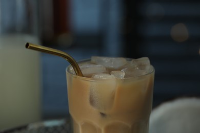 Photo of Glass of delicious iced coffee with straw on blurred background, closeup
