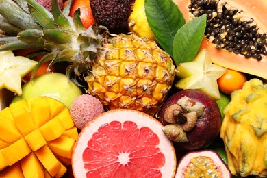 Photo of Different delicious exotic fruits as background, top view