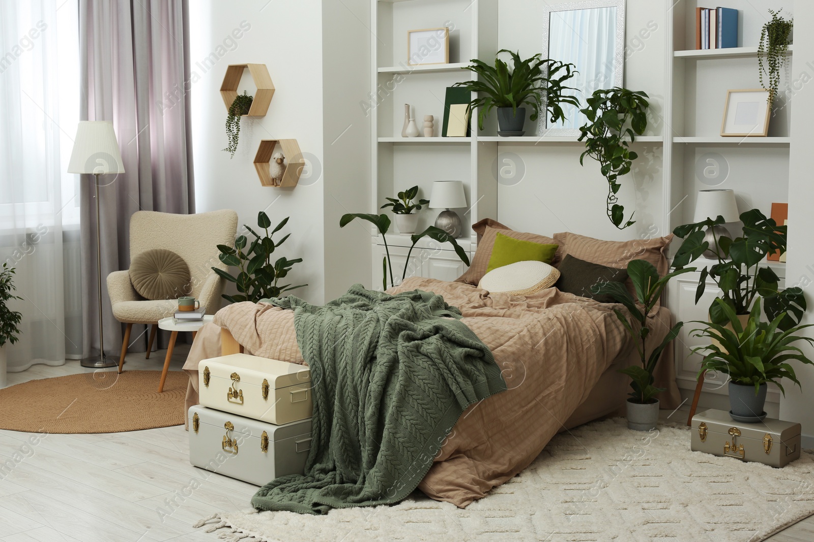 Photo of Stylish bedroom with comfortable bed and different houseplants. Interior design