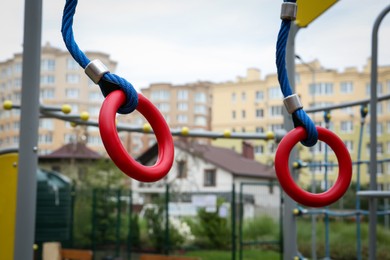 Photo of Gymnastic rings on outdoor playground in residential area