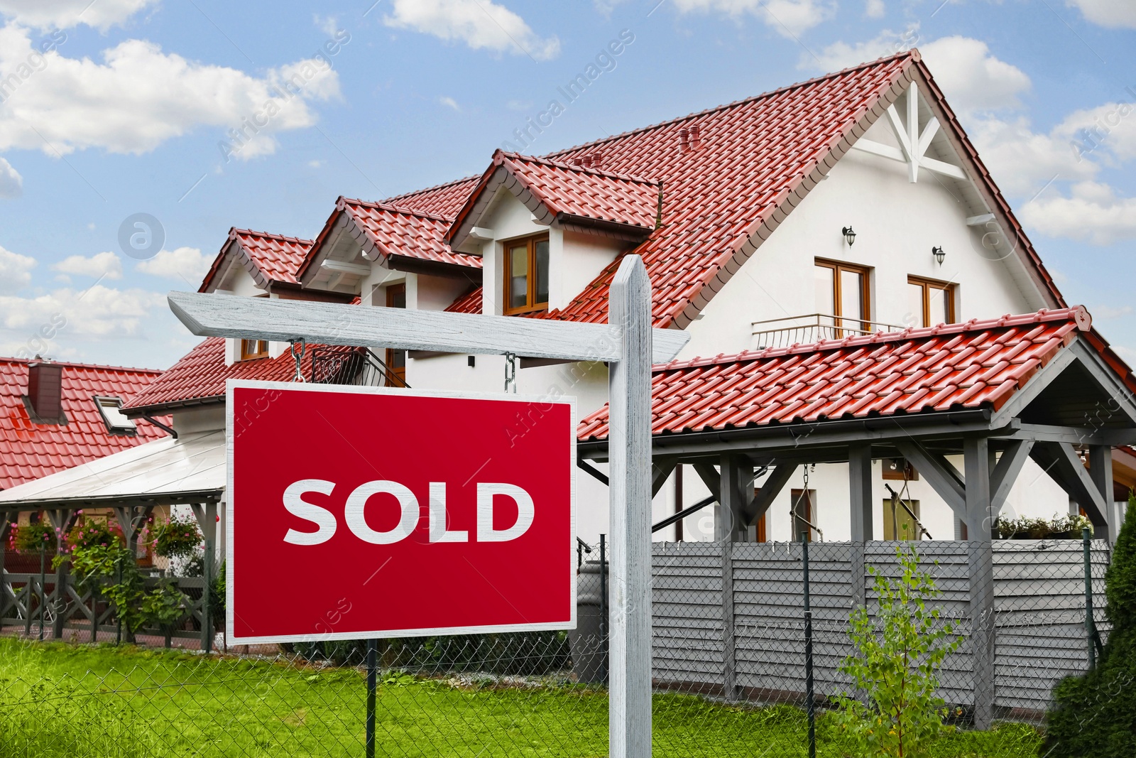 Image of Red Sold sign near beautiful house outdoors