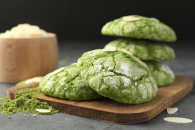 Photo of Tasty matcha cookies, almond flakes and powder on grey table, closeup