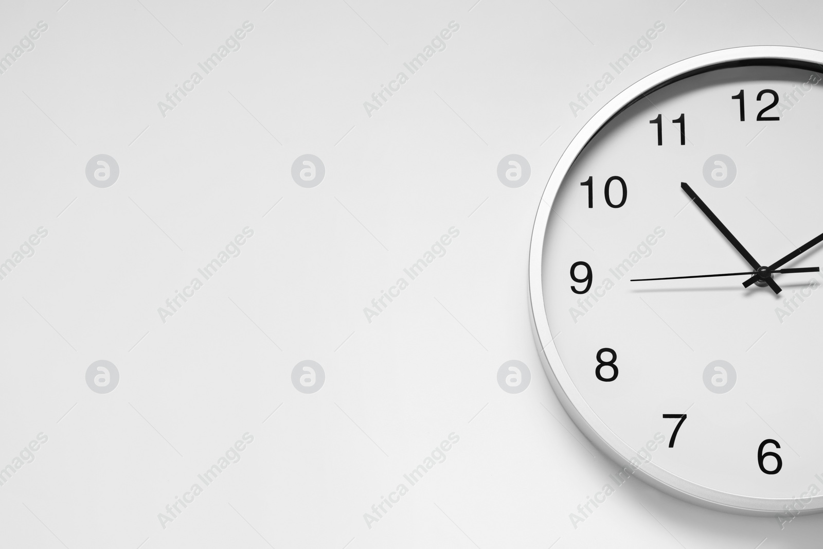 Photo of Stylish round clock on white background, top view with space for text. Interior element