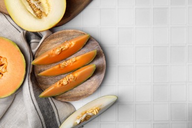 Tasty ripe melons on white checkered table, flat lay. Space for text