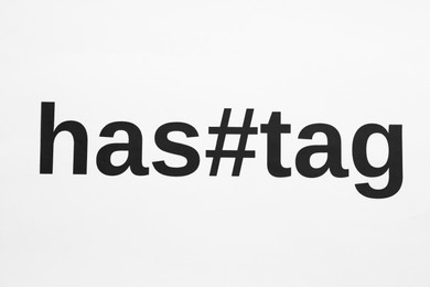 Photo of Word Hashtag with symbol on white background, top view