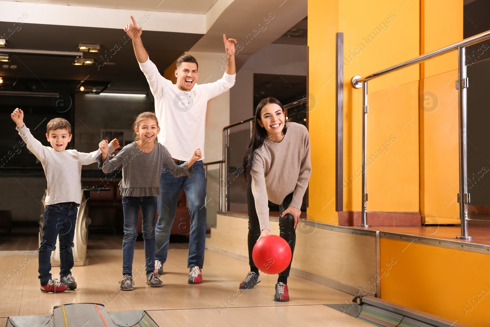 Photo of Happy family spending time together in bowling club