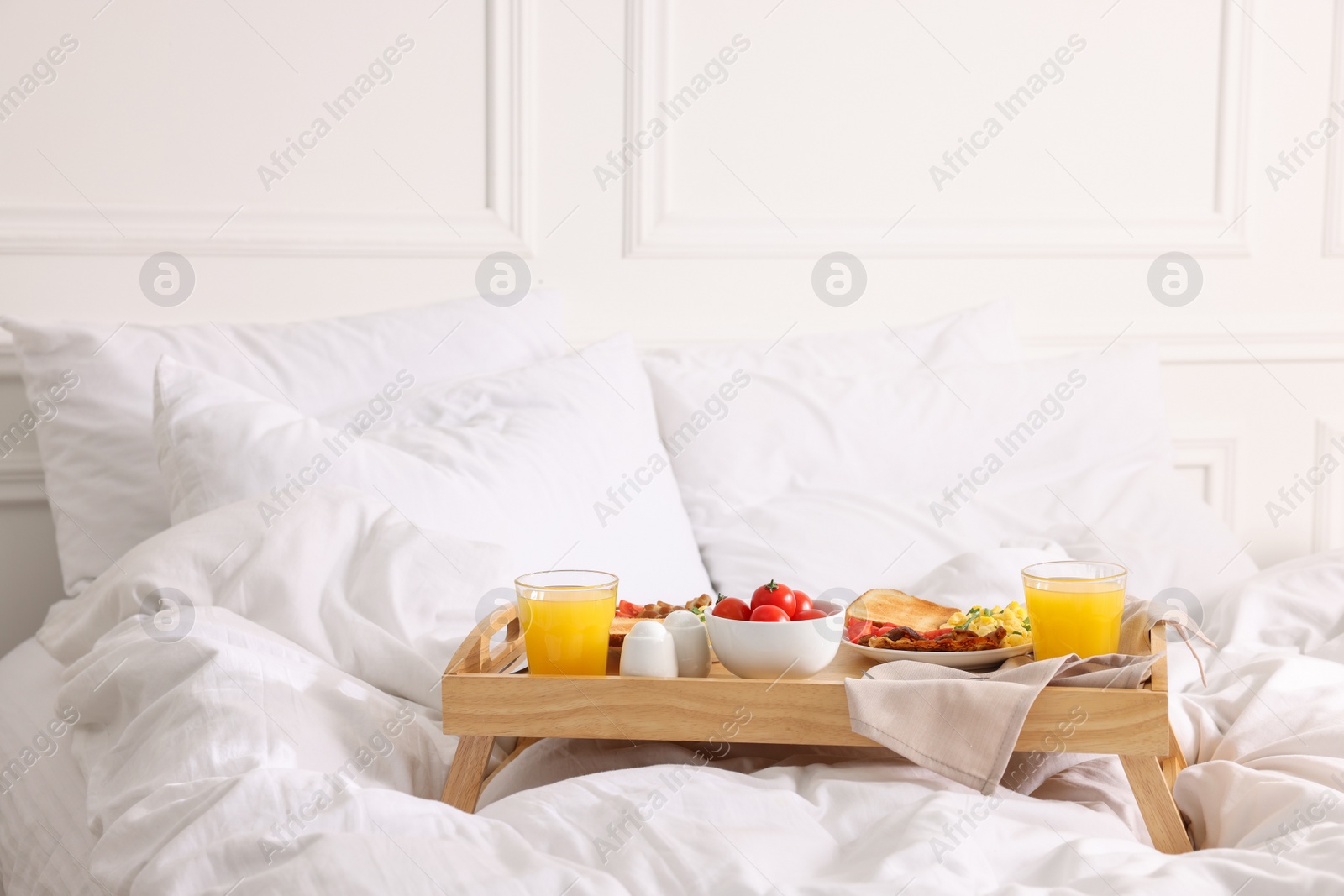 Good morning. Tray with tasty breakfast on bed at home. Space for text Photo of Good morning. Tray with tasty breakfast on bed at home. Space for text