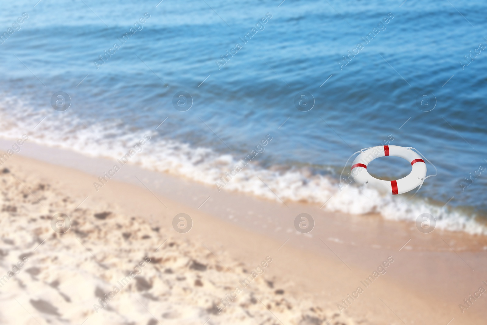 Image of Summer water safety. Life buoy floating in blue sea 