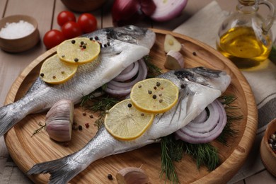 Raw dorado fish with lemon, spices and onion on table, closeup