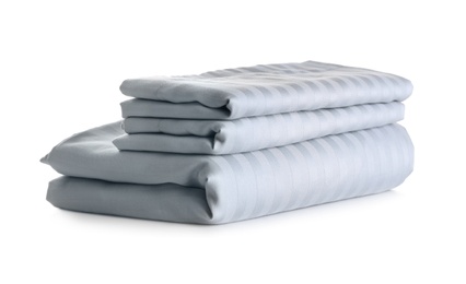 Stack of clean bed sheets isolated on white