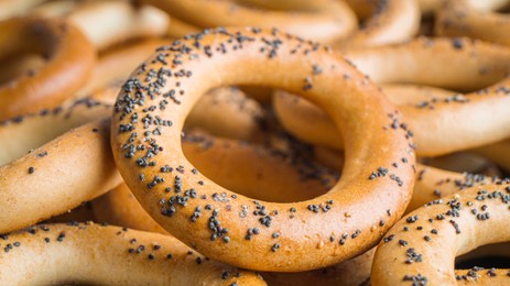Photo of Many delicious ring shaped Sushki (dry bagels) as background, closeup
