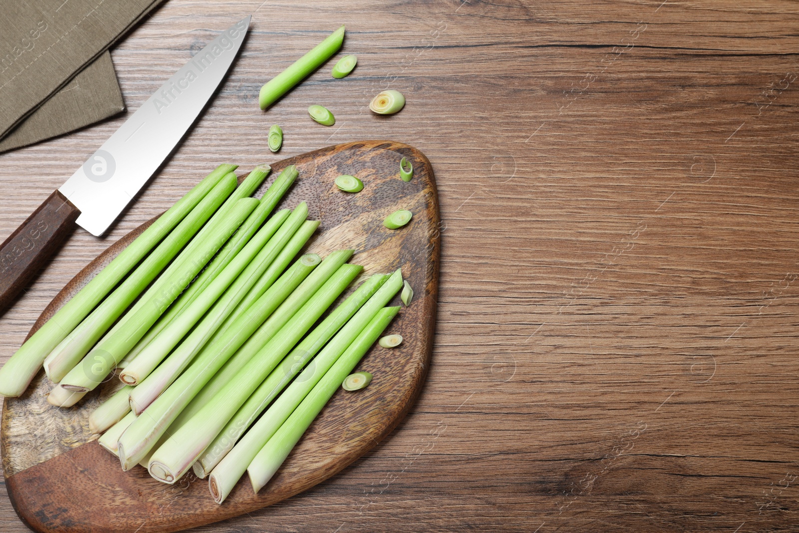 Photo of Flat lay composition with fresh lemongrass stalks on wooden table. Space for text