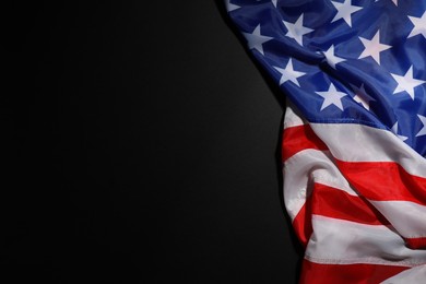 Photo of USA flag on black background, top view. Space for text