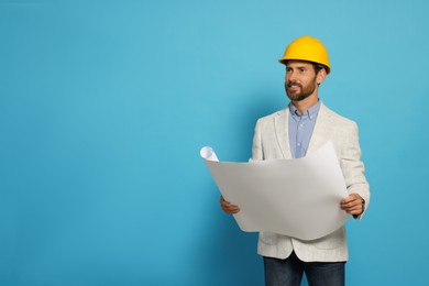 Photo of Professional engineer in hard hat with draft on light blue background, space for text