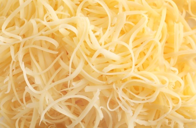 Fresh delicious grated cheese as background, closeup