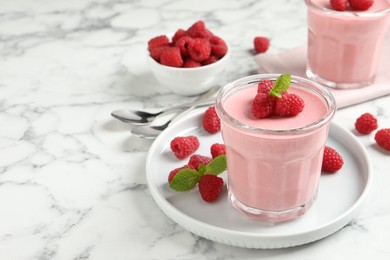 Photo of Delicious raspberry mousse with mint on white marble table, space for text