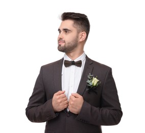 Handsome young groom with boutonniere on white background. Wedding accessory