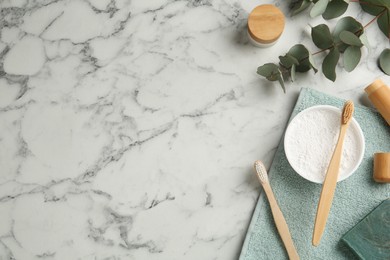 Photo of Flat lay composition with tooth powder and brushes on white marble table. Space for text