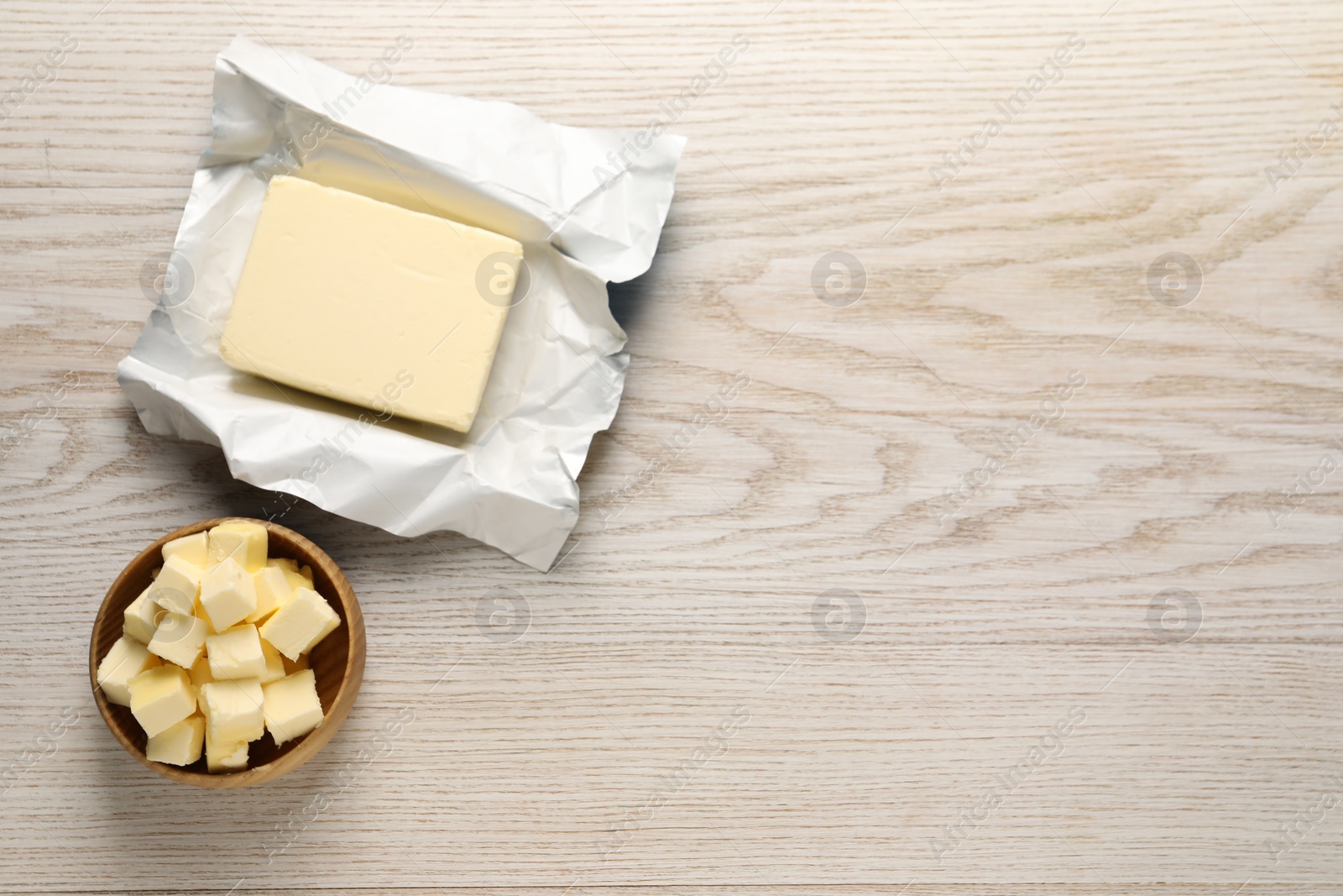 Photo of Tasty butter on light wooden table, flat lay. Space for text