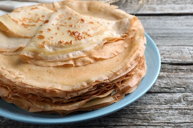 Stack of delicious crepes on wooden table, closeup