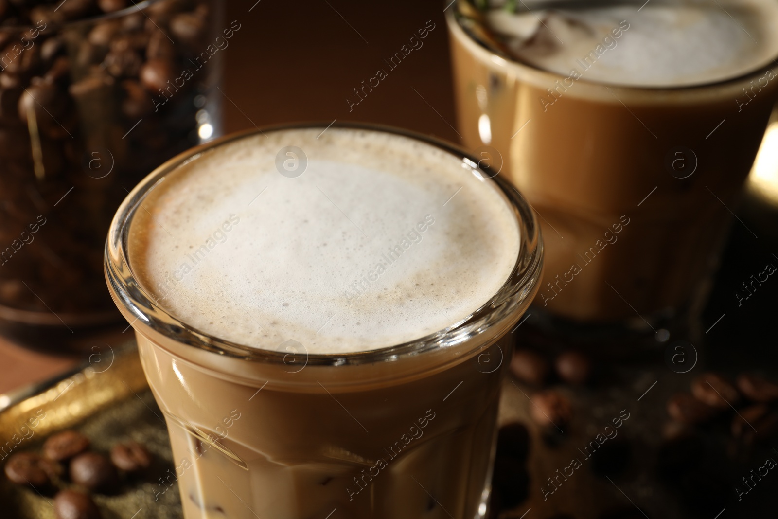 Photo of Refreshing iced coffee with milk in glasses on table, closeup