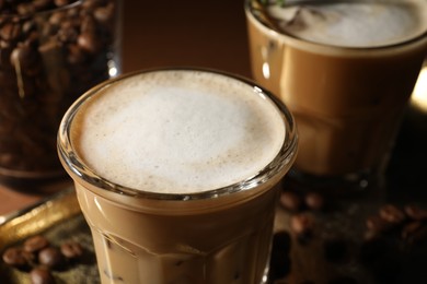 Refreshing iced coffee with milk in glasses on table, closeup