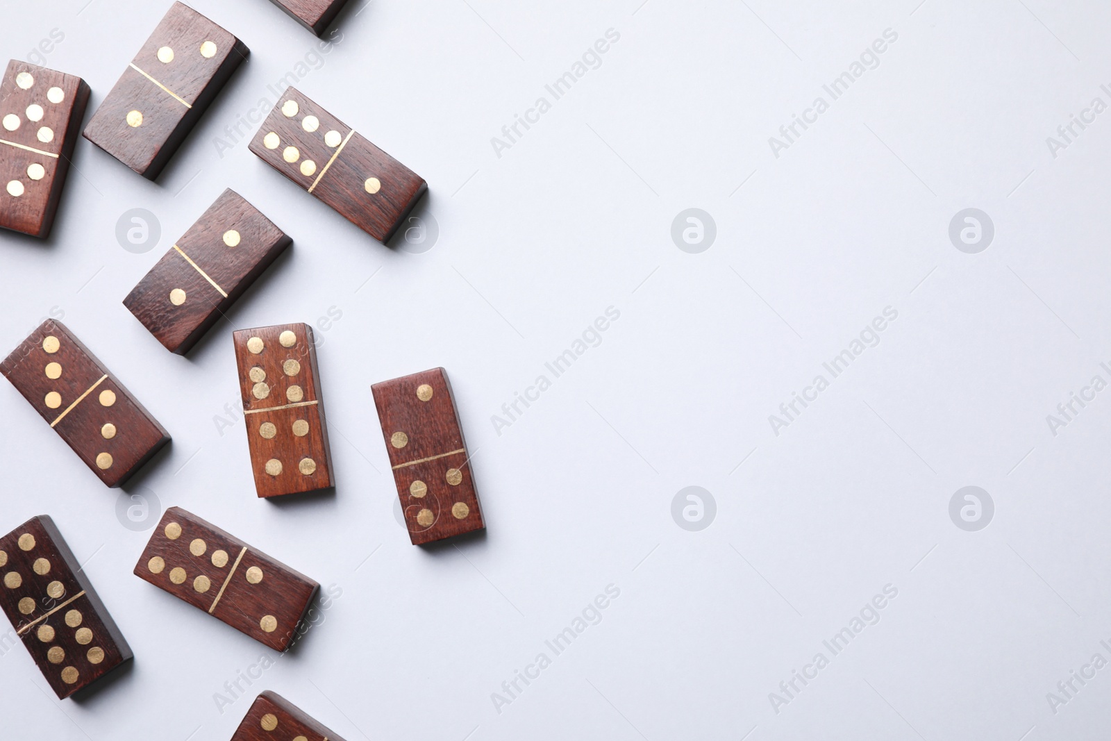 Photo of Wooden domino tiles on white background, flat lay. Space for text