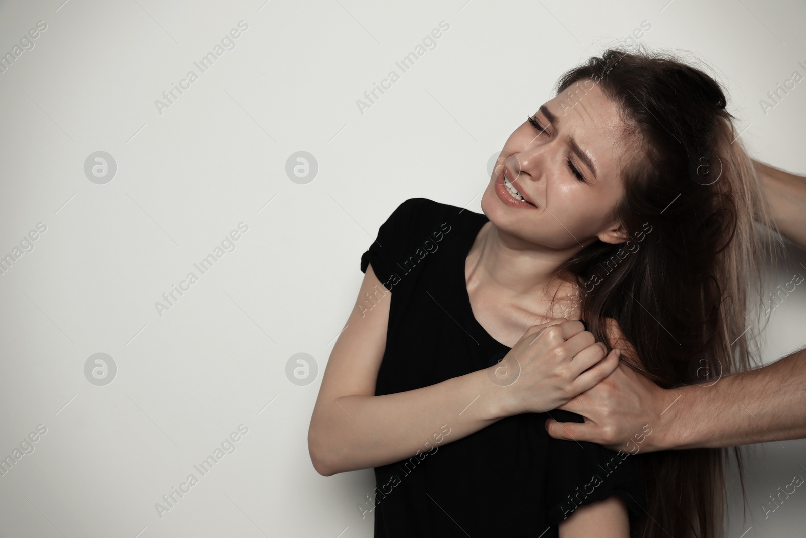 Photo of Man fighting with woman on light background, space for text. Stop sexual assault