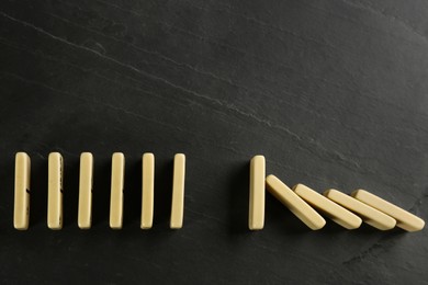 White domino tiles on dark grey background, flat lay