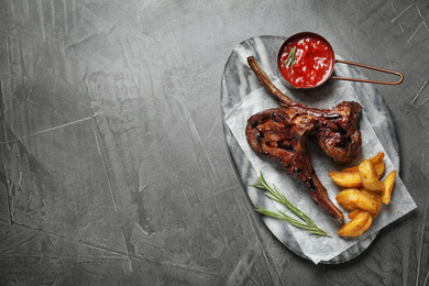 Photo of Delicious grilled ribs served on grey table, top view. Space for text