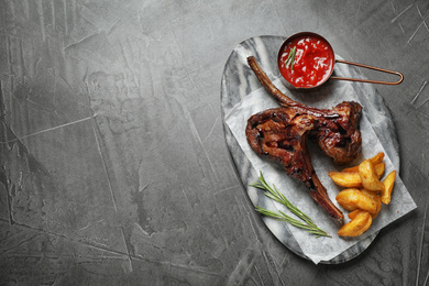 Delicious grilled ribs served on grey table, top view. Space for text