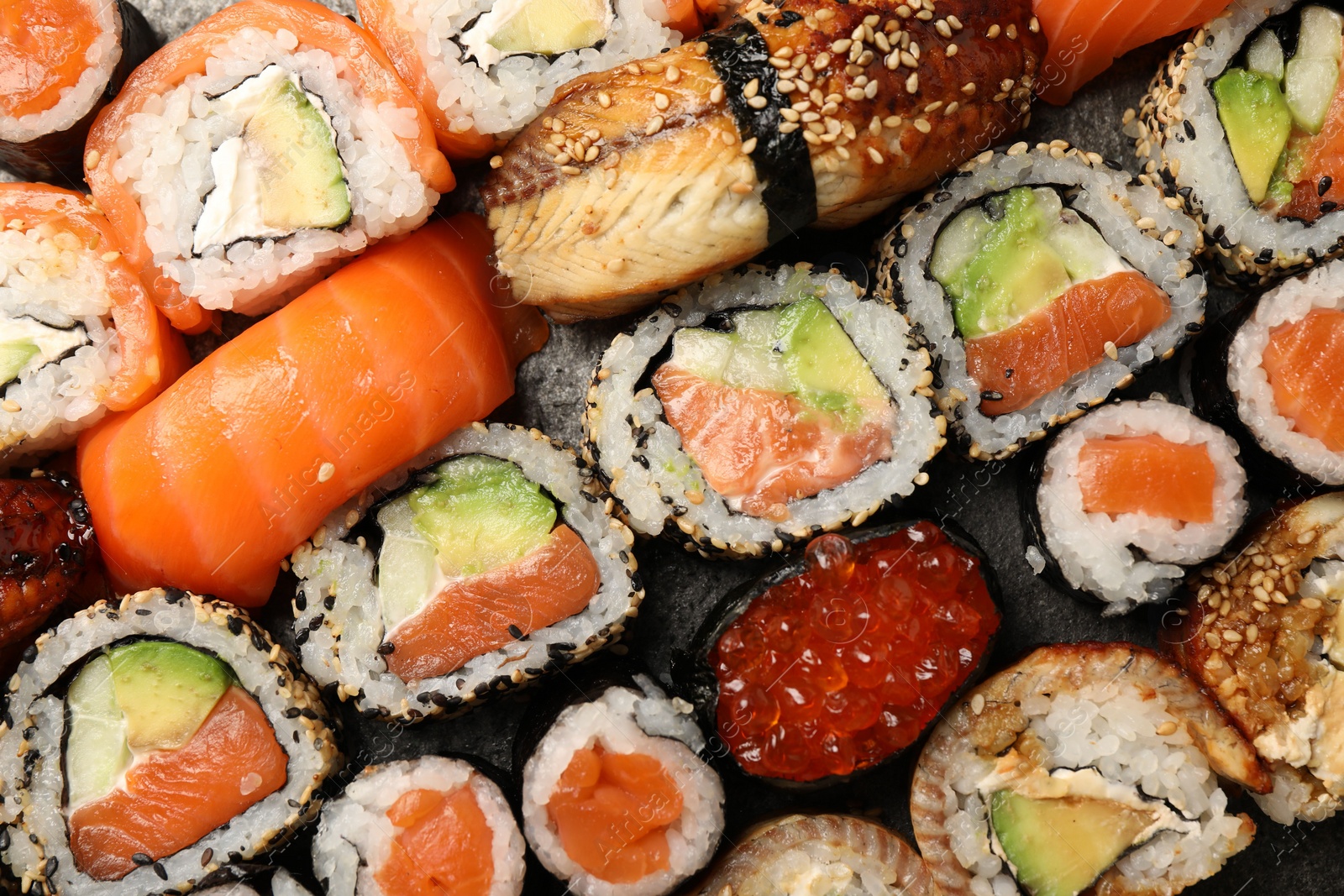 Photo of Different tasty sushi rolls as background, top view