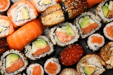 Different tasty sushi rolls as background, top view