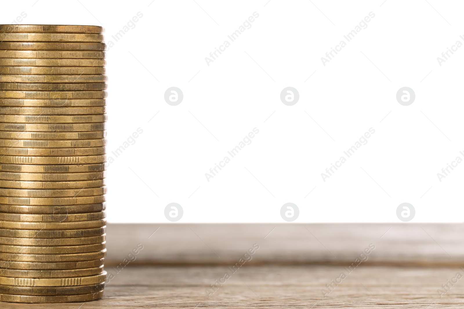 Photo of Stack of golden coins on wooden table, space for text