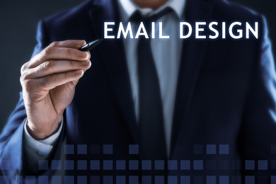 Image of Businessman pointing at phrase EMAIL DESIGN on virtual screen, closeup