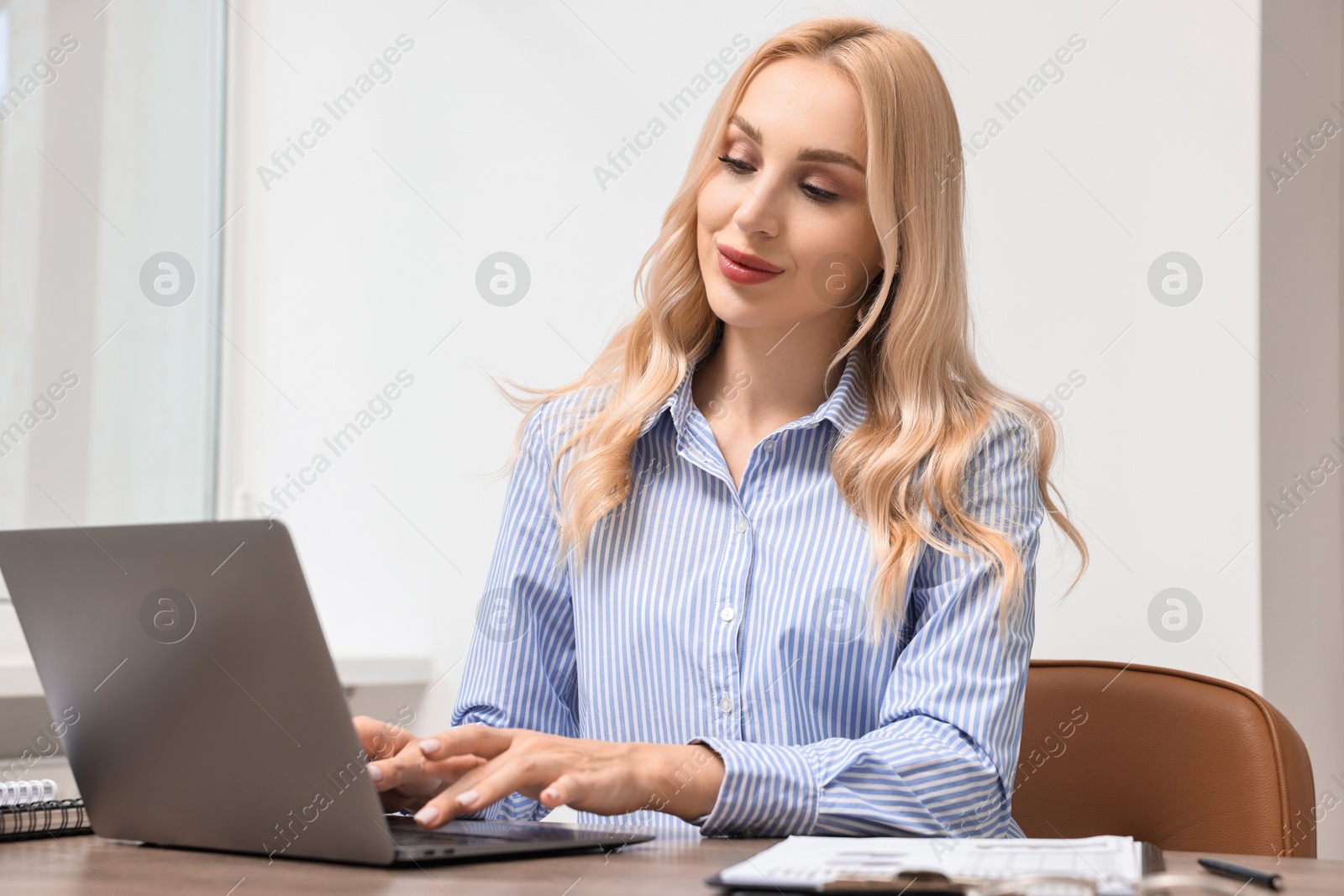 Photo of Secretary working with laptop at table in office