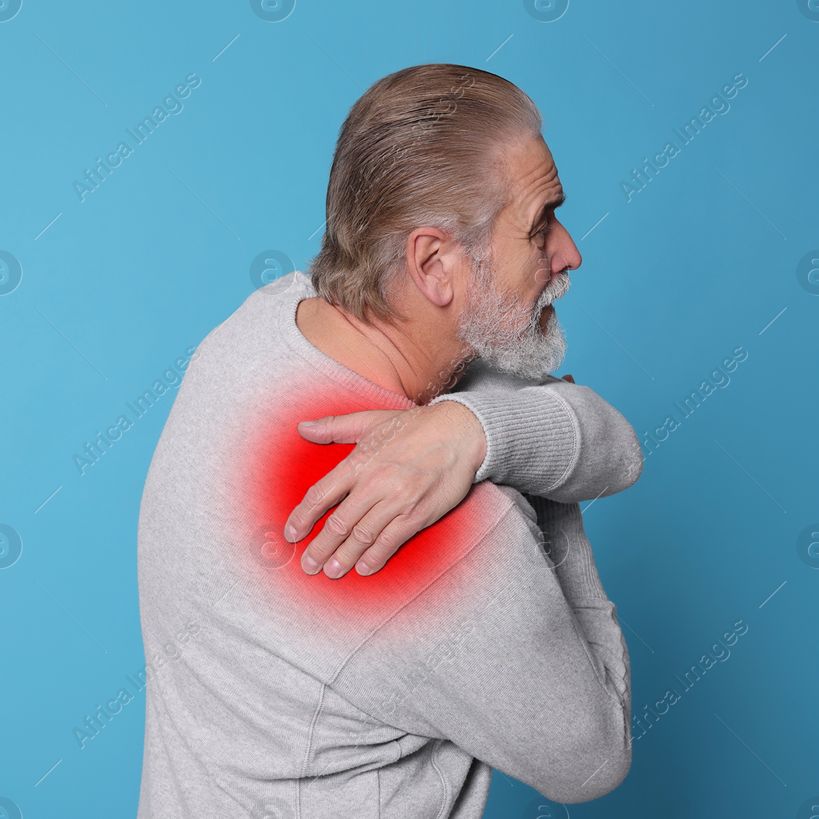 Image of Senior man suffering from rheumatism on light blue background