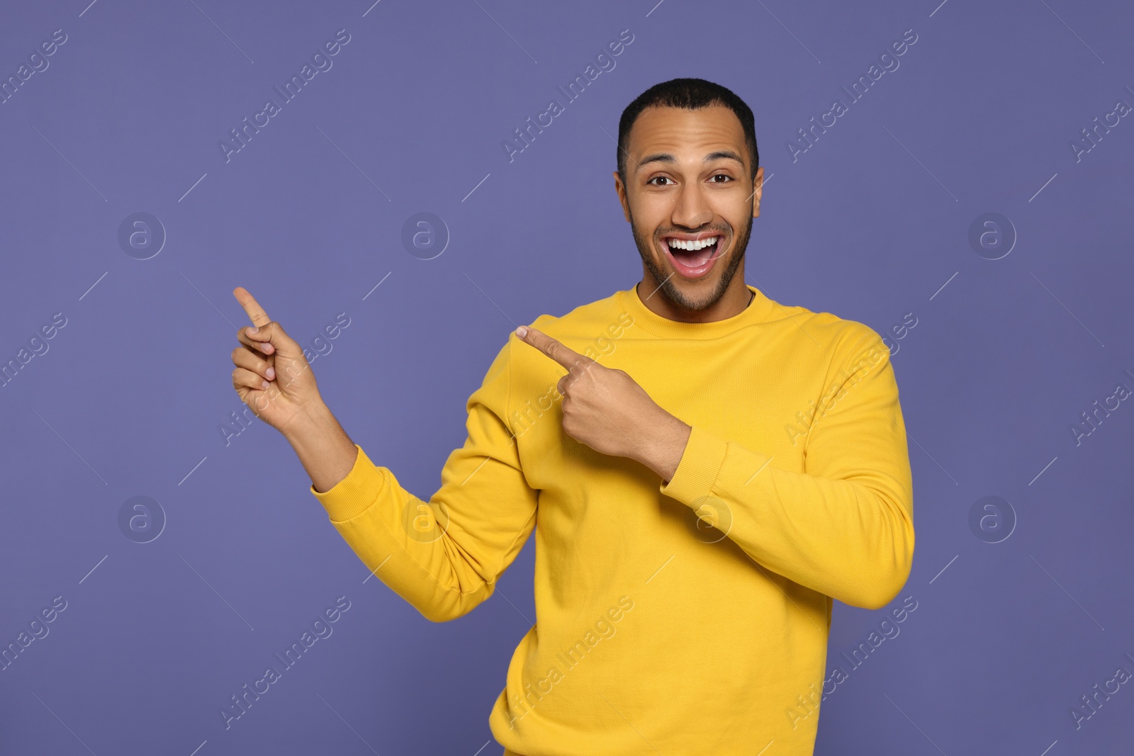 Photo of Portrait of happy African American man on purple background. Space for text