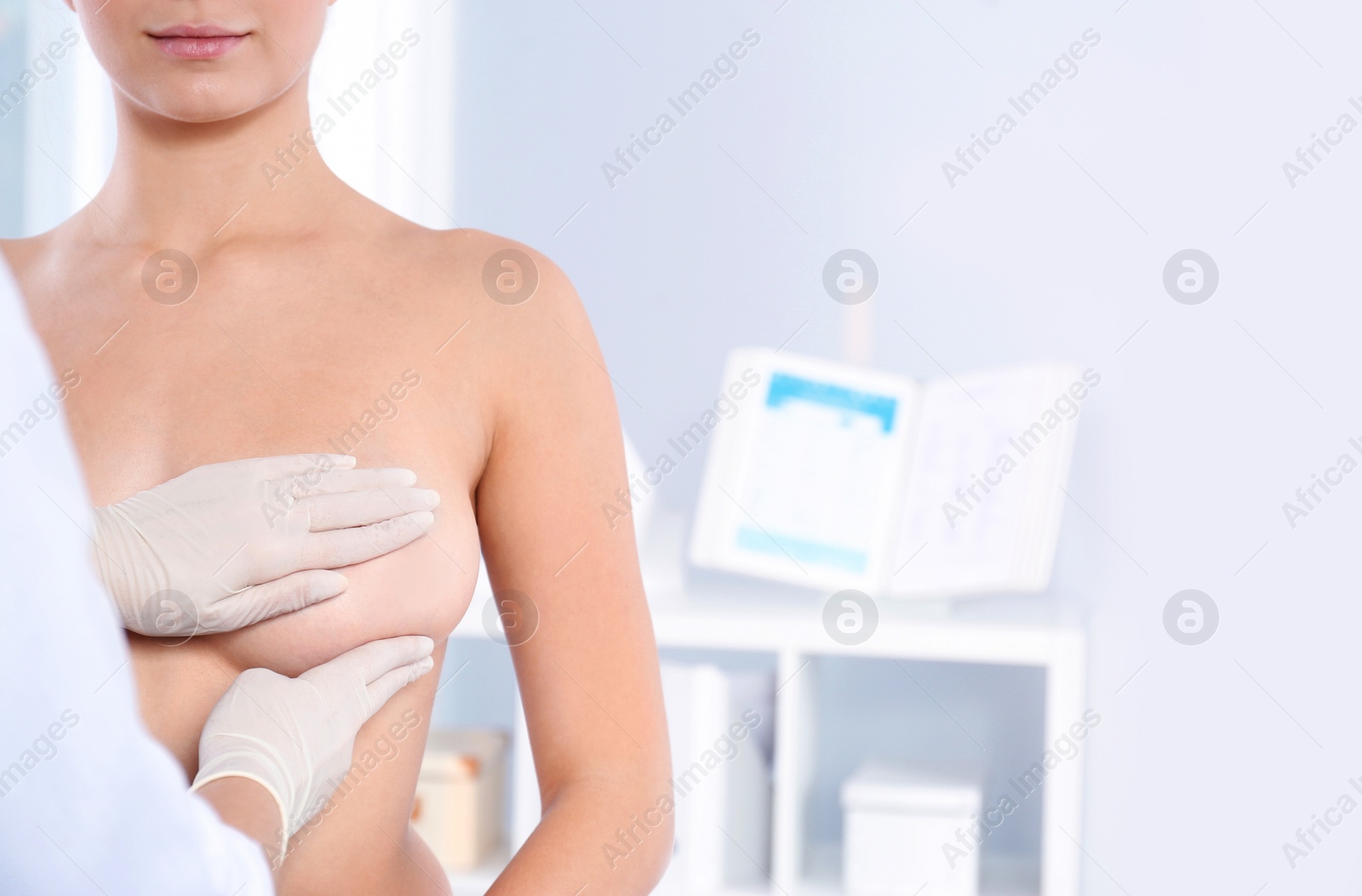 Photo of Doctor checking woman's breast at hospital, closeup. Space for text