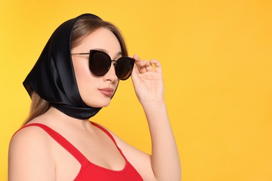 Photo of Young woman with lip piercing and sunglasses on yellow background, space for text